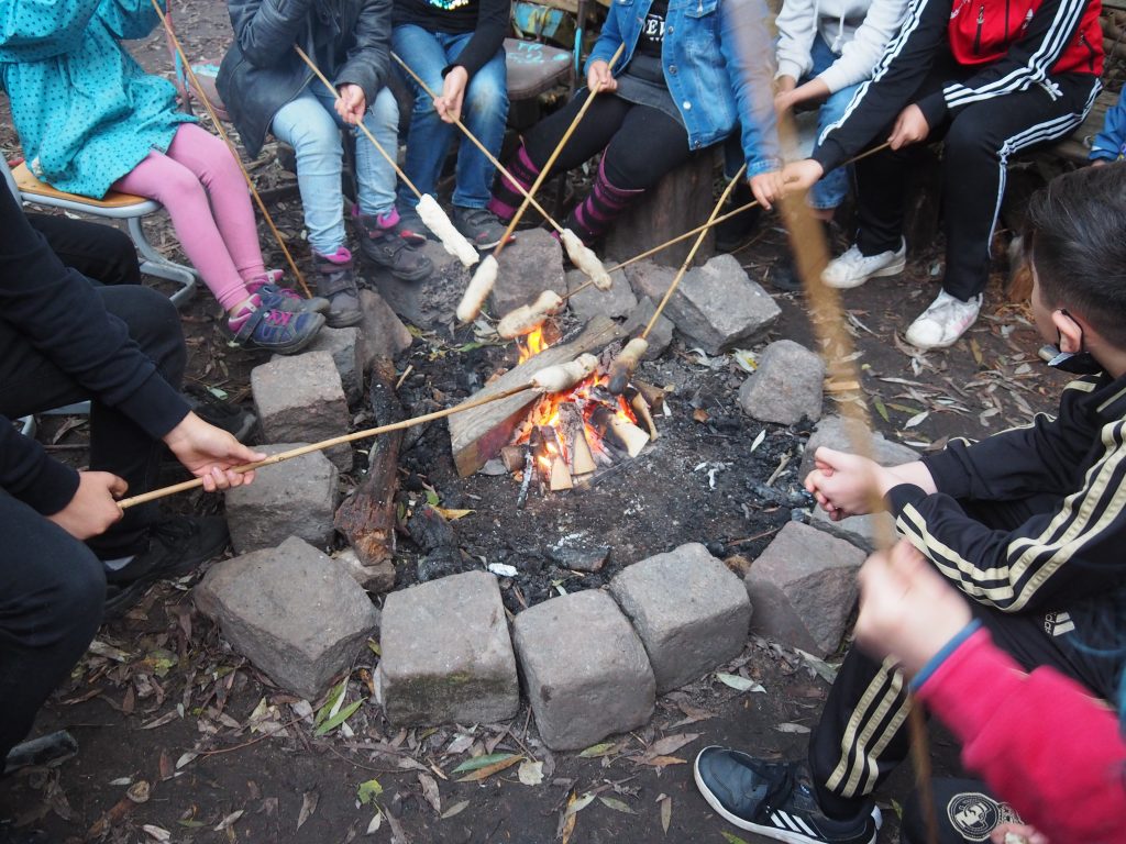 Kinder mit Stockbroten am Lagerfeuer Kreativgarten e.V